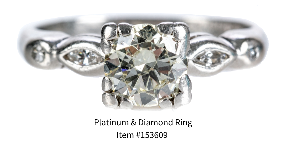A platinum and diamond engagement ring (size 6.25) featuring a round cut center diamond flanked on each side with accent diamonds.